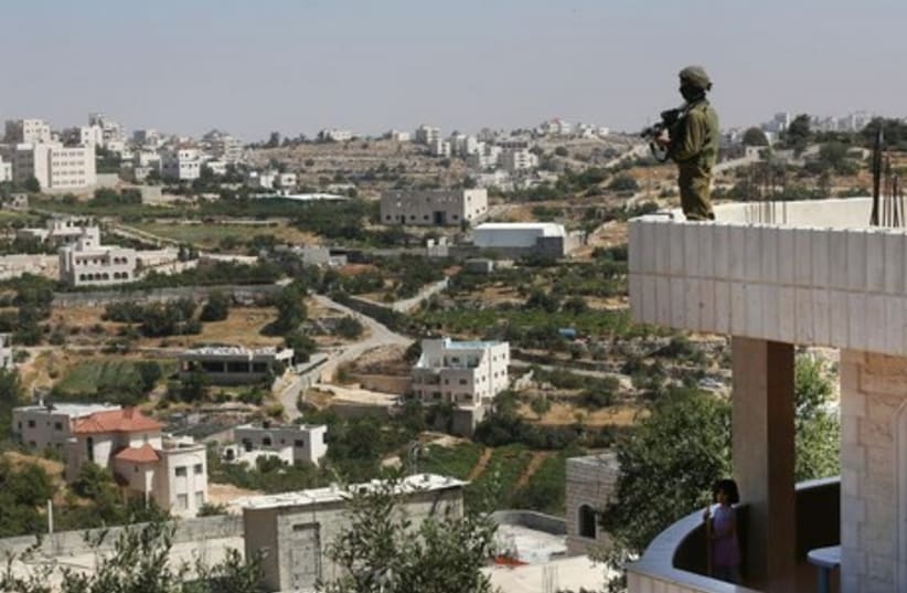 An IDF soldier gazes out over Hebron in search of three missing teens. (photo credit: MARC ISRAEL SELLEM)
