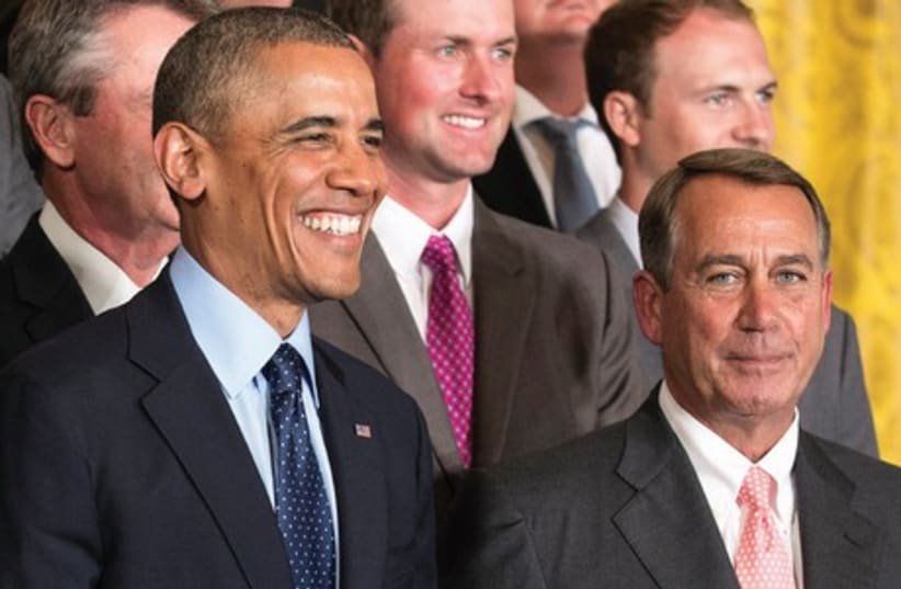 US President Barack Obama stands with Speaker of the House John Boehner during a ceremony honoring the President’s Cup golf teams in the East Room of the White House in Washington. (photo credit: REUTERS)