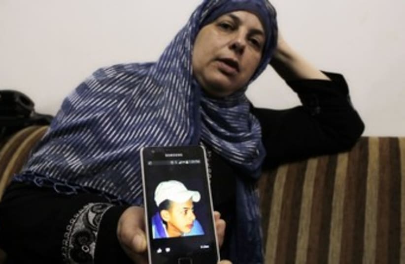 Suha, mother of Mohammed Abu Khudair, shows a picture of her son on her mobile phone at their home in Shuafat. (photo credit: REUTERS)
