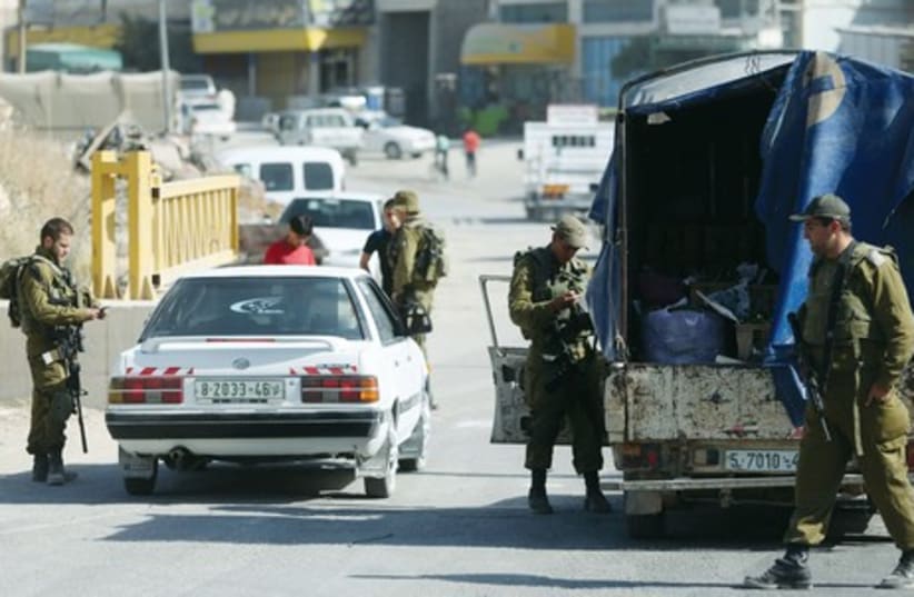 IDF soldiers man a checkpoint in Hebron on June 17 (photo credit: MARC ISRAEL SELLEM/THE JERUSALEM POST)