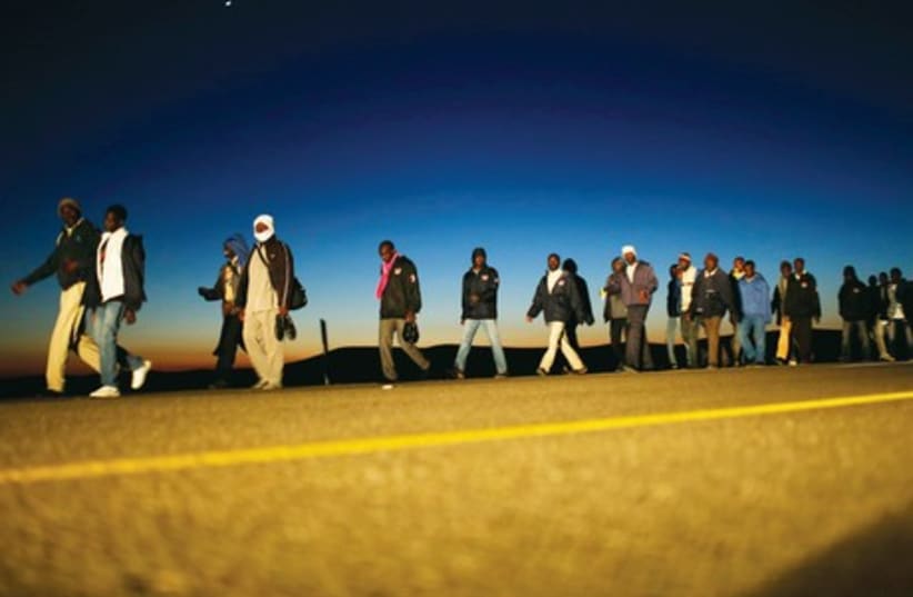 African migrants walk on a road in December 2013 after choosing to leave the Holot open detention facility (photo credit: REUTERS)