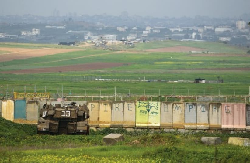 An IDF tank positions itself outside the border of the northern Gaza Strip in this photo from March 2014 (photo credit: REUTERS)
