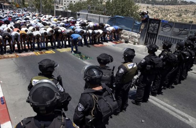Palestinians pray on the first Friday of Ramadan in the Wadi al-Joz section of east Jerusalem. (photo credit: REUTERS)