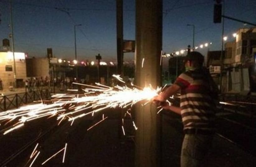 Palestinian taking a disk-saw to an electricity pole in Jerusalem, July 4, 2014.  (photo credit: ISRAEL POLICE)