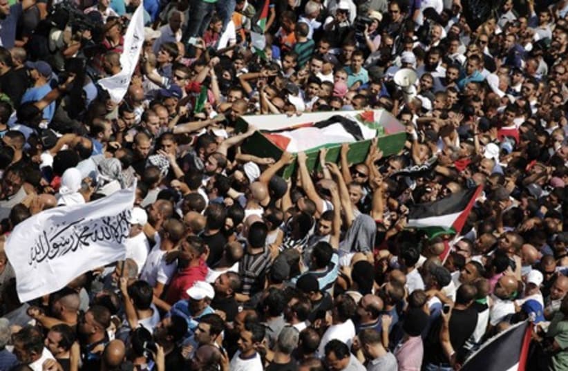 Palestinians carry the body of Mohammed Abu Khdeir during his funeral in Shuafat (photo credit: REUTERS)