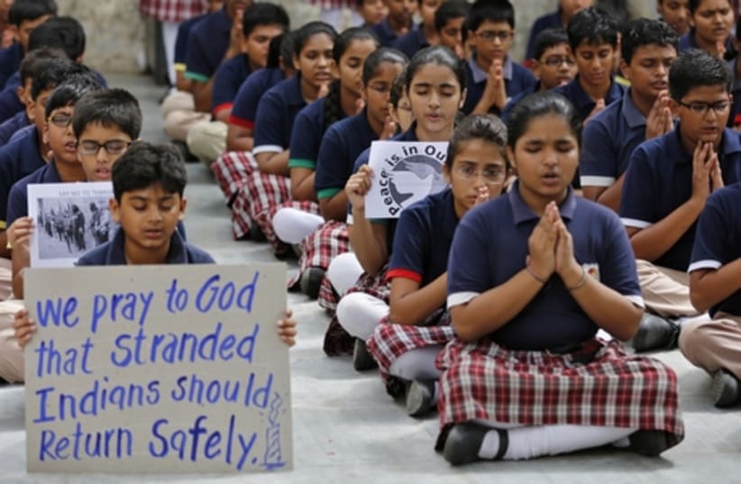 School students pray for the Indian citizens kidnapped in Iraq, at a school in the western Indian city of Ahmedabad June 20, 2014. India has learned the location of 40 of its citizens kidnapped in Iraq by suspected Islamist militants and believes they are being held captive with workers of other nat (photo credit: REUTERS/AMIT DAVE)