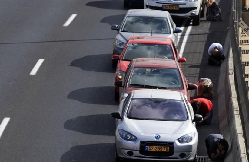 Drivers take cover as sirens sounds in Tel Aviv  (photo credit: REUTERS)