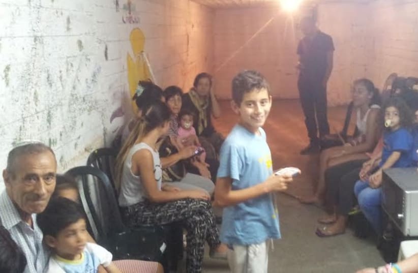 People stand in bomb shelter in Tel Aviv during rocket siren (photo credit: Courtesy)