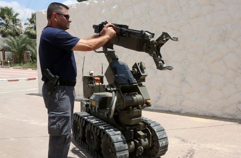 A POLICE SAPPER from the Negev Subdistrict inspects a bomb disposal robot. (photo credit: MARC ISRAEL SELLEM/THE JERUSALEM POST)
