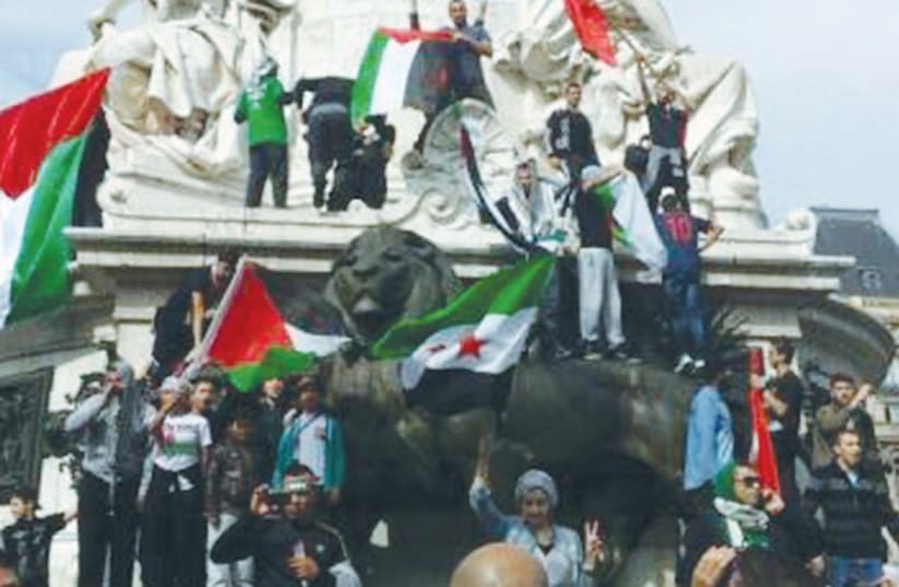 ANTI-ISRAEL PROTESTERS display Palestinian flags at the Place de la Bastille in Paris. (photo credit: DAVID YAEL)