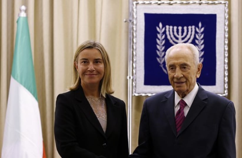 President Peres shakes hands with Italy's Foreign Minister Mogherini at the start of their meeting in Jerusalem (photo credit: REUTERS)