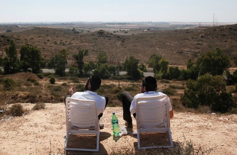 Two students watch the bombardment of Gaza on July 10. (photo credit: REUTERS)