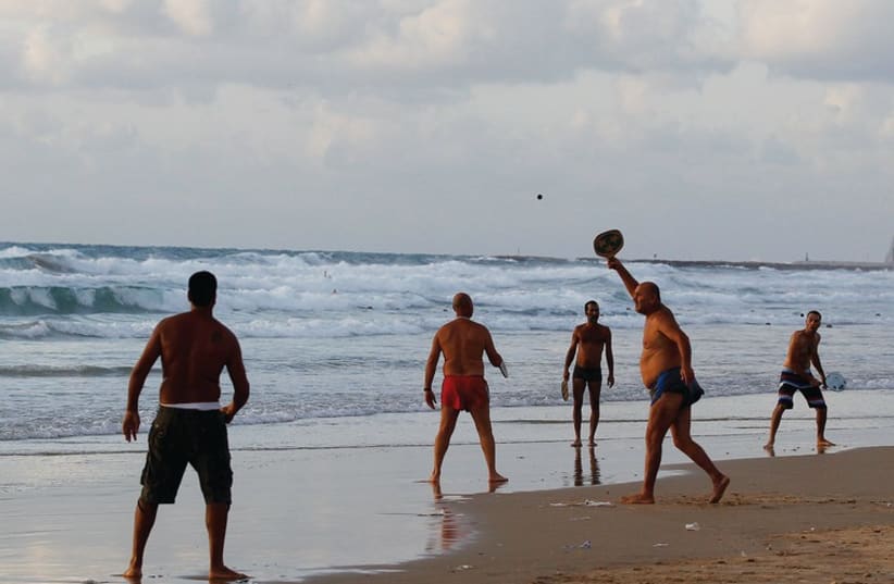 Beach-goers play paddleball in Tel Aviv. (photo credit: REUTERS)