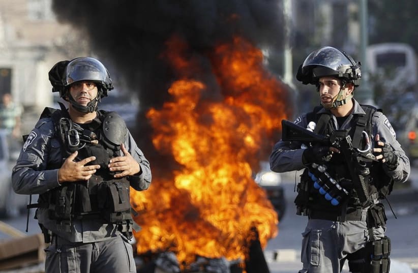 Israeli police officers stand guard during a protest by Israeli Arabs in the northern city of Nazareth. (photo credit: REUTERS)