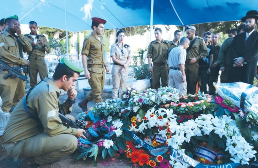 Mourners attend the funeral of Sgt. Shon Mondshine at the Nahalat Yitzhak cemetery in Tel Aviv yesterday. (photo credit: YAACOV NAUMI / FLASH 90)