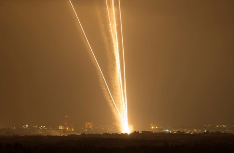 Light streaks and smoke trails are seen as rockets are launched from Gaza towards Israel July 23, 2014 (photo credit: REUTERS)