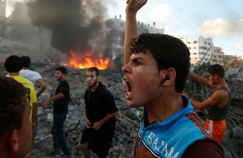 A Palestinian reacts following what witnesses said was an Israeli air strike on a building in Gaza City July 24, 2014. (photo credit: REUTERS)
