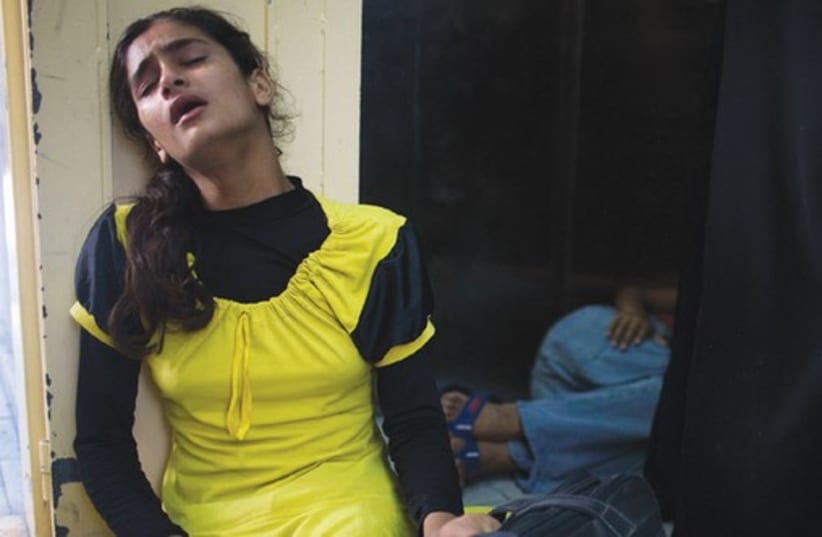 A Palestinian girl who fled shelling that hit a UN-run school sits in shock at a hospital in Beit Hanun in the northern Gaza Strip. (photo credit: REUTERS)