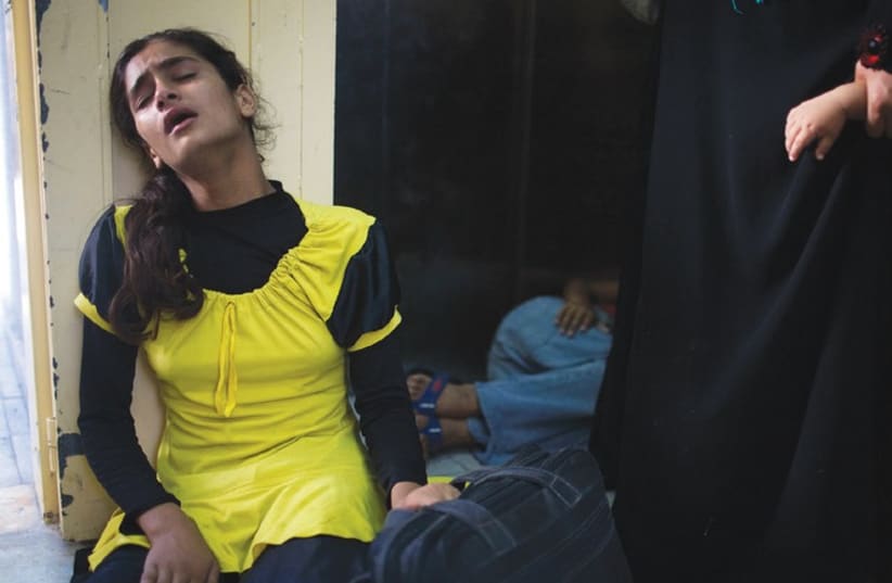 A Palestinian girl who fled shelling that hit a UN-run school sits in shock at a hospital in Beit Hanun in the northern Gaza Strip. (photo credit: REUTERS)