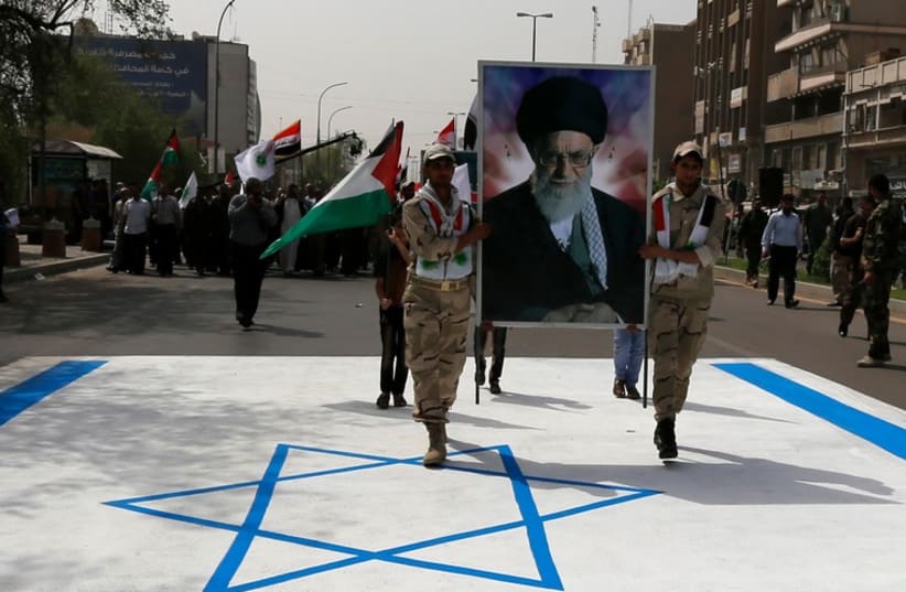 Iraqi muslims from Shi'ite Badr organization hold a portrait of Ayatollah Ali Khamenei as they walk over the Israeli flag during a parade marking Jerusalem Day. (photo credit: REUTERS)