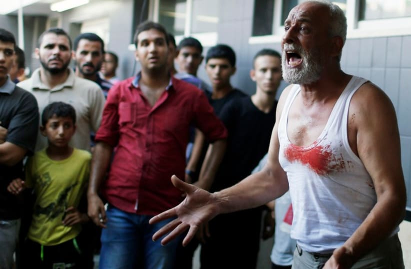 The father of a Palestinian boy reacts following his death at a hospital in Gaza City July 28, 2014. (photo credit: REBECCA FRIEDMAN)