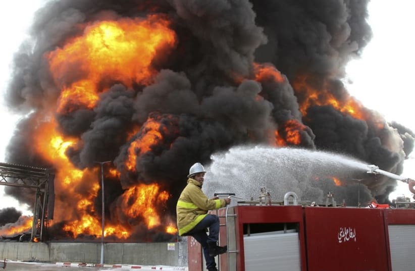 A Palestinian firefighter works during efforts to extinguish a fire at Gaza's main power plant. (photo credit: REUTERS)