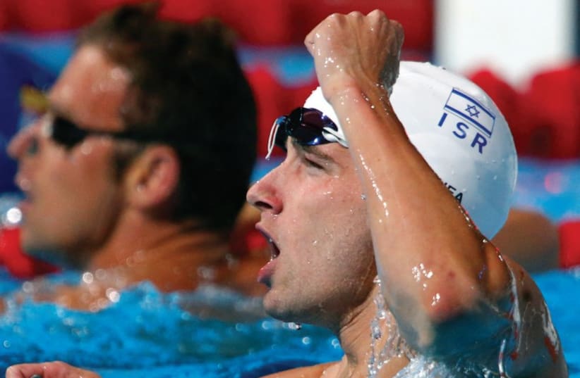 Swimmer Guy Barnea says he is especially proud to have the Israel flag on his cap in times like these. (photo credit: REUTERS)