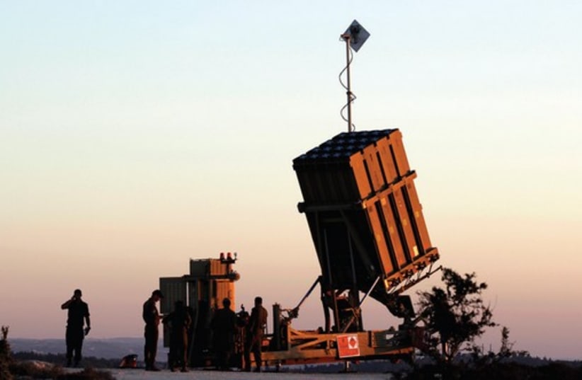 Soldiers stand next to an Iron Dome battery. (photo credit: REUTERS)