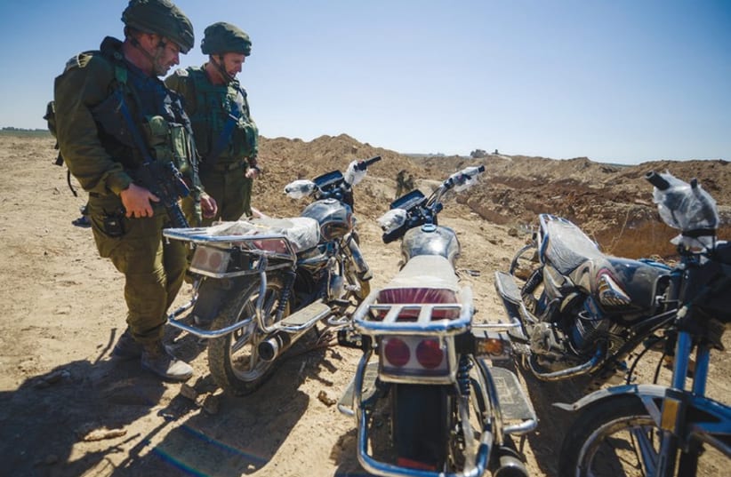 SOLDIERS EXAMINE three motorcycles discovered last week in a tunnel in the Karni crossing area that terrorists intended to use in an attack on communities near the Gaza border. (photo credit: IDF)