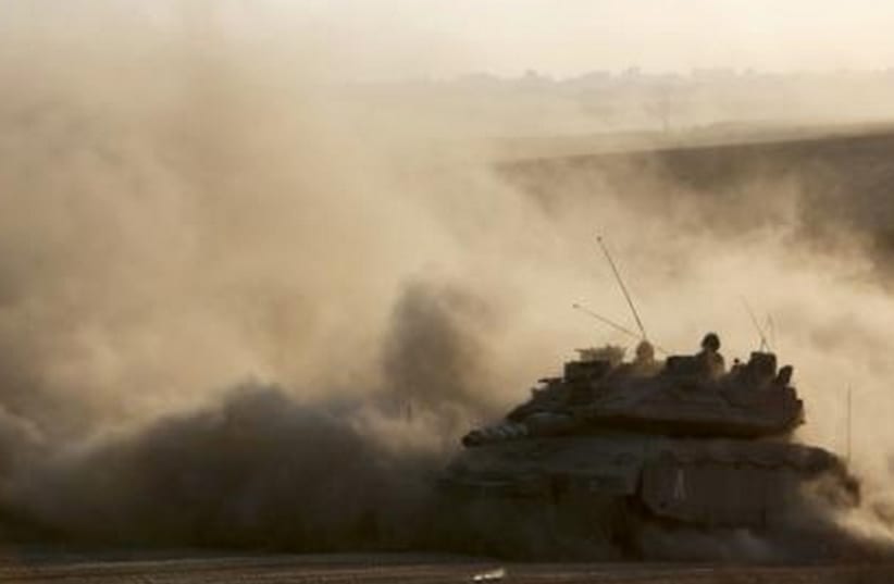 An Israeli tank drives near the border as it returns to Israel from Gaza. (photo credit: REUTERS)