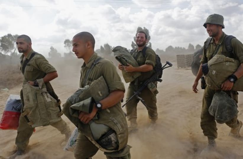 Israeli soldiers arrive at a staging area near the border with Gaza Strip (photo credit: REUTERS)