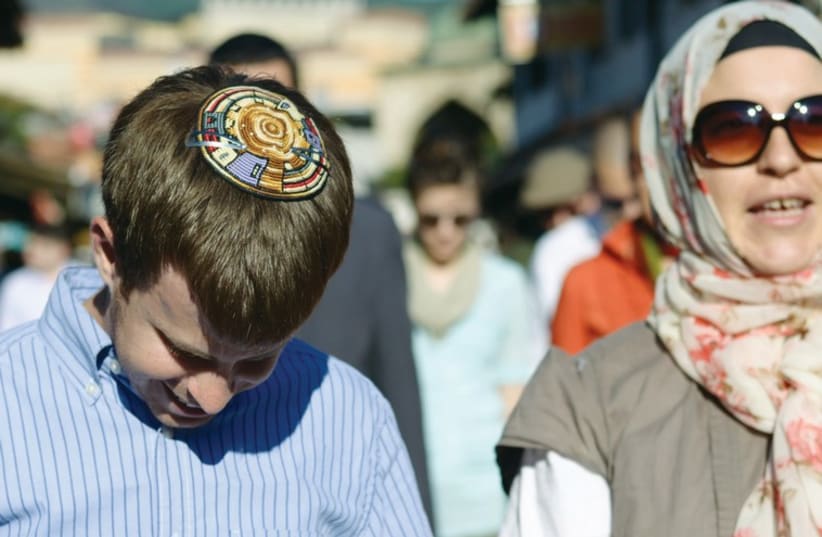 A jewish boy and Muslim woman walk during a city tour in an earlier Muslim Jewish Conference. (photo credit: COURTESY MJC)