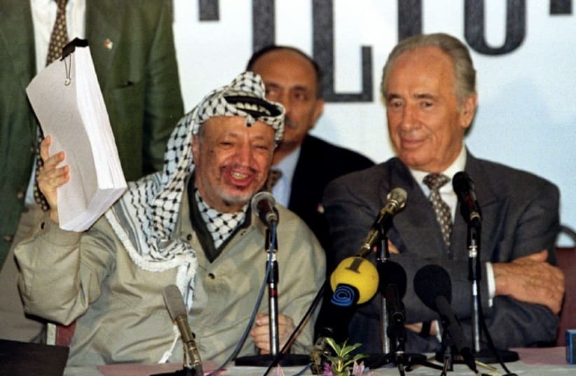 PLO chairman Yasser Arafat holds the second phase of the Oslo peace accords after the initialling of the document, September 24. (photo credit: REUTERS)