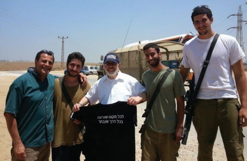 RABBI GOLDIN (holding the shirt) distributes items to soldiers on the border. (photo credit: LEE WEIBLATT)