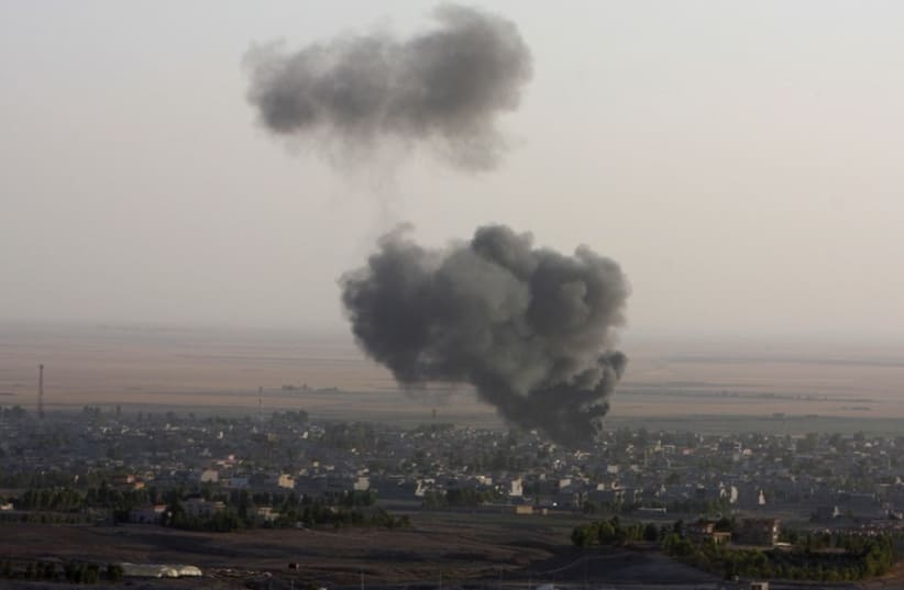 Smoke billows from the town of Makhmur during clashes between Iraqi Kurdish Peshmerga troops and Islamic State (IS) militants. (photo credit: REUTERS)