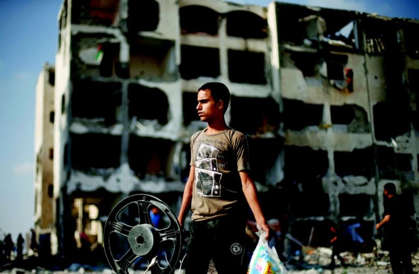 Jeune Palestinien de Beit Lahiya devant son immeuble en ruine (photo credit: REUTERS)