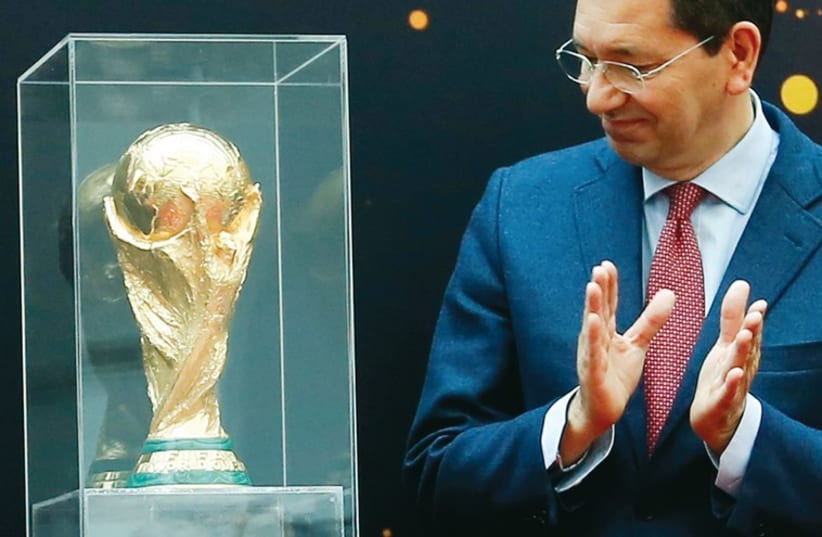 Rome's Mayor Ignazio Marino claps next to the World Cup trophy, in Rome in February. (photo credit: REUTERS)