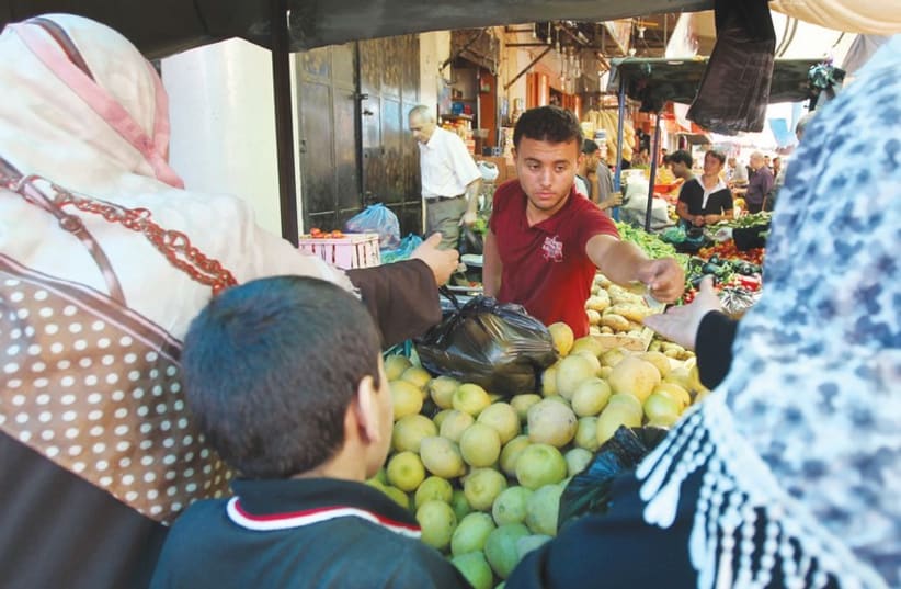 Palestinian shop at a market in Gaza City. (photo credit: REUTERS)