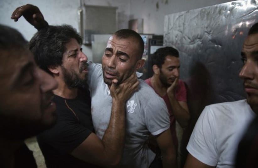 A Palestinian father reacts at the Shifa Hospital morgue after his son was killed in an explosion. (photo credit: REUTERS)