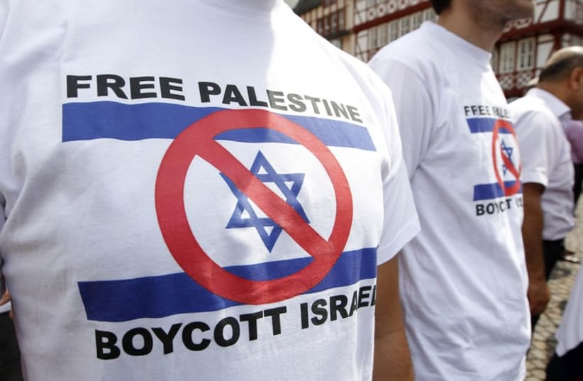 Demonstrators wearing t-shirts depicting a defaced Israeli flag attend a protest against the Israeli offensive in the Gaza Strip, in Frankfurt July 26, 2014. (photo credit: REUTERS)