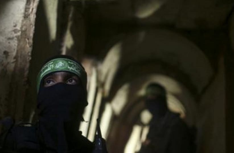 Palestinian fighters from the Izz el-Deen al-Qassam Brigades stand inside an underground tunnel in Gaza August 18 (photo credit: REUTERS)