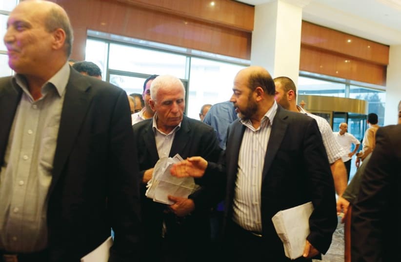 Moussa Abu Marzouk (right) talks with Fatah official and delegation leader Azzam Ahmed (photo credit: REUTERS)