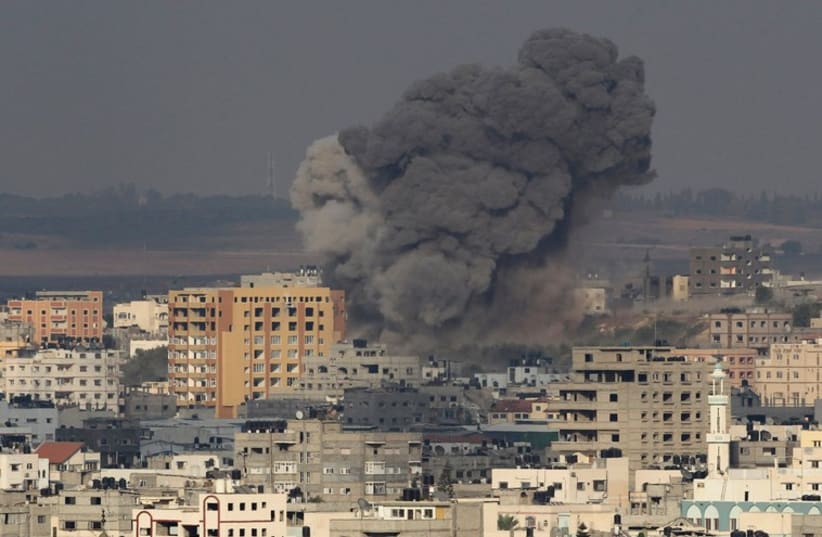 Smoke rises from an apparent air strike by Israel in the Gaza Strip. (photo credit: REUTERS)