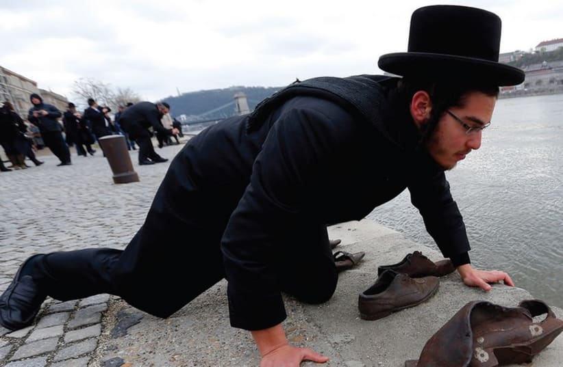 An Orthodox rabbi says a prayer at a Holocaust memorial in Budapest. (photo credit: REUTERS)