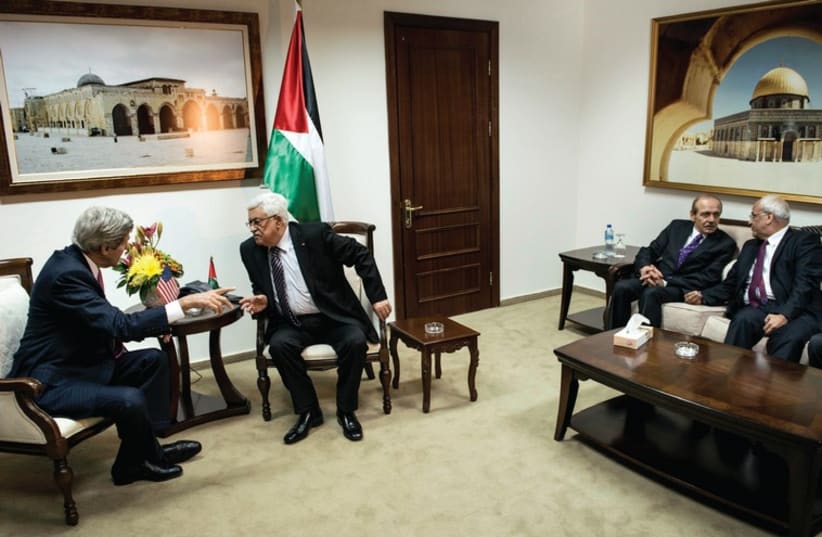 US SECRETARY of State John Kerry and Palestinian Authority President Mahmoud Abbas talk while PLO Executive Committee member Yasser Abed Rabbo and Palestinian negotiator Saeb Erekat talk on the side during a meeting at the presidential compound in Ramallah. (photo credit: REUTERS)