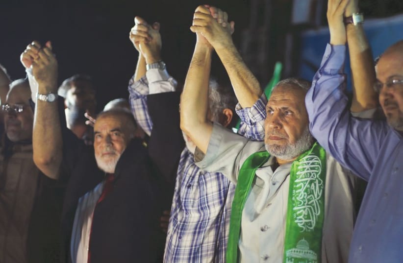 SENIOR HAMAS LEADER Mahmoud Zahar (second right), appearing in public for the first time since the 50-day began, attends a rally in Gaza City celebrating the cease-fire that began yesterday evening. (photo credit: REUTERS)
