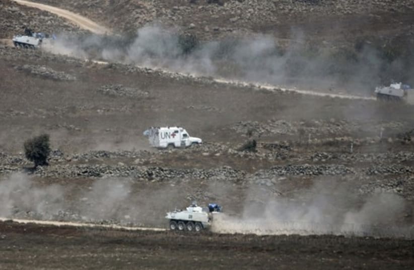 U.N. vehicles drive in Syria, near the border fence with the Israeli-occupied Golan Heights. (photo credit: REUTERS)