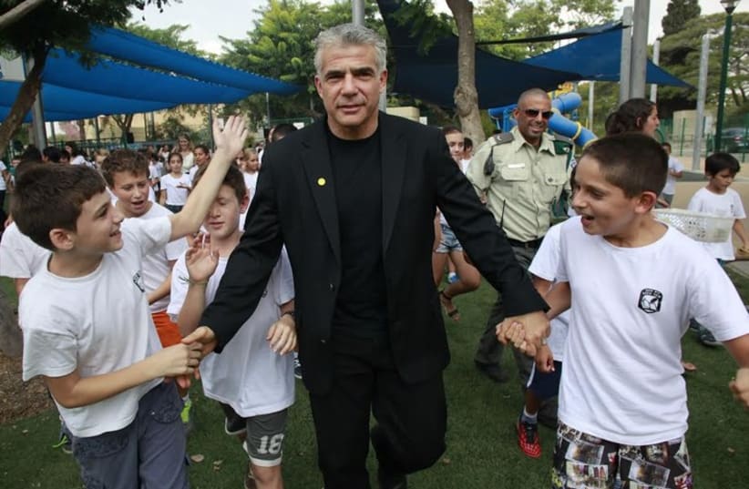 Finance Minister Yair Lapid with first-graders in Sha'ar Hanegev. (photo credit: RAANAN COHEN)