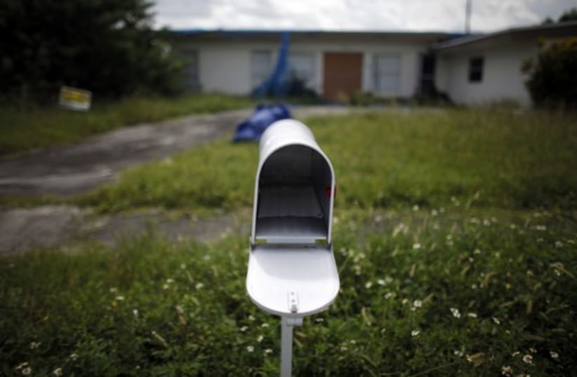 An empty mail box is seen at the front door of a foreclosed house (photo credit: REUTERS)