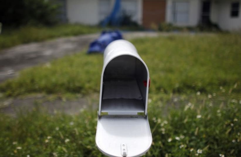 An empty mail box is seen at the front door of a foreclosed house (photo credit: REUTERS)